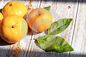 Group of fresh orange fruits on wooden background with light sunshine and shadow