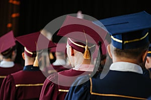 Group of fresh university graduates with robes and caps in ceremony