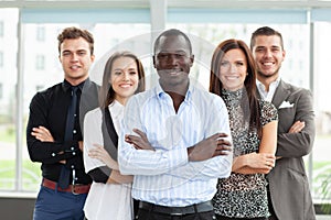 Group of friendly businesspeople with male leader in front.