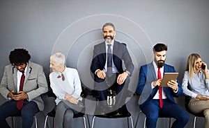 Group of friendly businesspeople with male leader in front