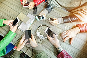 Group of friends are addicted using mobile phone devices - Upper point of view people hands using smart cell phones together -