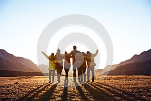 Group of friends against sunset mountains