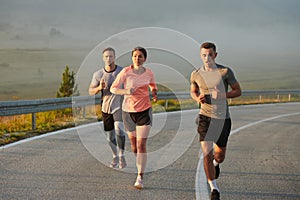 A group of friends, athletes, and joggers embrace the early morning hours as they run through the misty dawn, energized