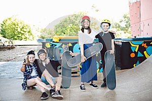 Group of friends athletes skateboarders posing together in a skate park. Caucasian children having fun together on sports urban