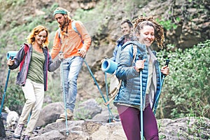 Group of friends with backpacks doing trekking excursion on mountain - Young tourists walking and exploring the nature