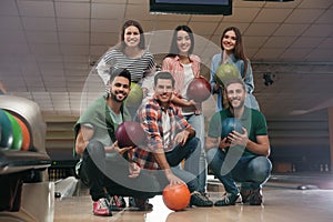 Group of friends with balls in bowling