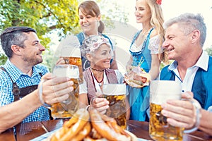 Group of friends in beer garden toasting to camera