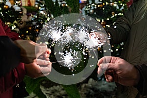 Group of friends burning Bengal lights during winter time celebrations, Christmas, New Year`s Eve