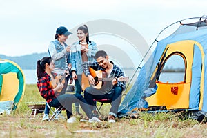 Group of friends camping and they are sitting playing guitar. Camp and music guitar concept