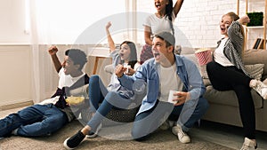 Group of Friends Celebrating Exciting Moment in Living Room