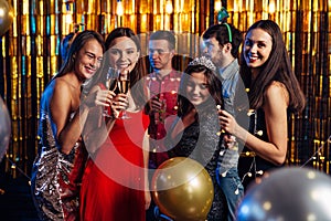 Group of friends celebrating with fireworks and glasses enjoying Christmas party