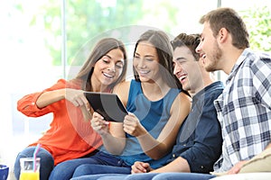 Group of friends checking tablet content at home