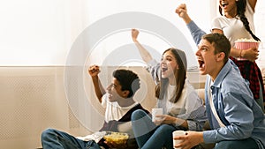 Group of Friends Cheering Excitedly During a Home Viewing Party