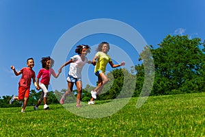 Group of friends children run fast in the park