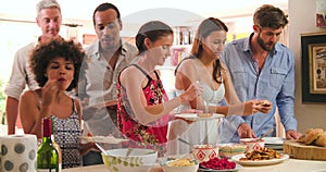 Group Of Friends Choosing Food From Party Buffet At Home