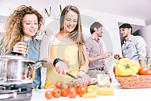 Group of friends cooking at home to have dinner together