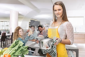 Group of friends cooking at home to have dinner together