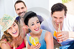 Group of friends drinking cocktails in beach bar