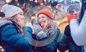 Group of friends drinking mulled wine in the cold on a Christmas Market