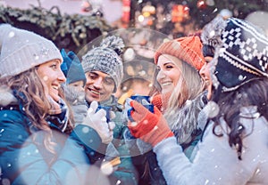 Group of friends drinking mulled wine in the cold on a Christmas Market