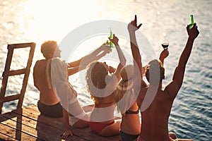 Group of friends drinking together on the lake