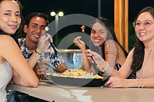 Group of friends eating fast food in a restaurant. Cheerful young people eating and enjoying themselves in a fast food restaurant