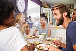 Group Of Friends Enjoying Breakfast In Kitchen Together