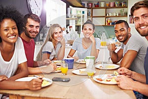 Group Of Friends Enjoying Breakfast In Kitchen Together