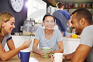 Group Of Friends Enjoying Breakfast In Kitchen Together