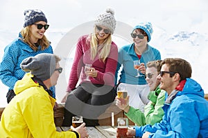 Group Of Friends Enjoying Drink In Bar At Ski Resort
