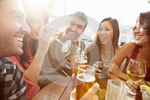 Group Of Friends Enjoying Drink At Outdoor Rooftop Bar