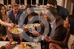 Group Of Friends Enjoying Drinks And Snacks At Party