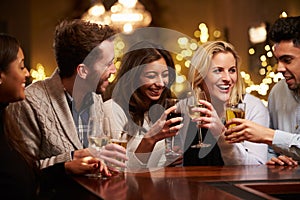 Group Of Friends Enjoying Evening Drinks In Bar