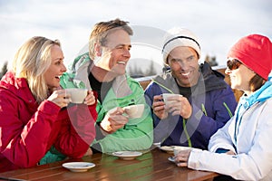 Group Of Friends Enjoying Hot Drink At Ski Resort