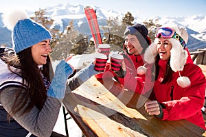 Group Of Friends Enjoying Hot Mulled Wine In Cafe At Ski Resort.