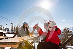 Group Of Friends Enjoying Hot Mulled Wine In Cafe At Ski Resort.