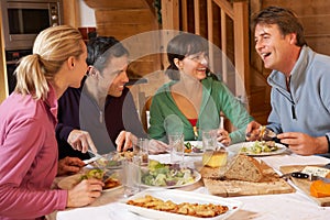 Group Of Friends Enjoying Meal In Alpine Chalet