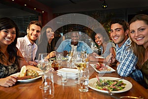 Group Of Friends Enjoying Meal In Restaurant