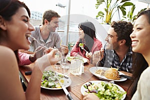 Group Of Friends Enjoying Meal At Rooftop Restaurant