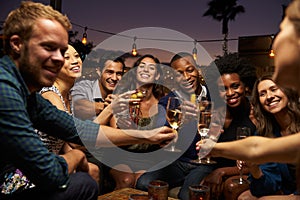 Group Of Friends Enjoying Night Out At Rooftop Bar photo