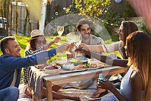 Group Of Friends Enjoying Outdoor Picnic In Garden