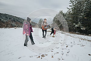 Group of friends enjoying a snowy forest hike during winter photo