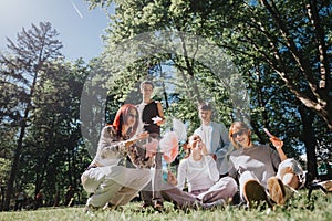 Group of friends enjoying a sunny day in the park with cotton candy and drinks