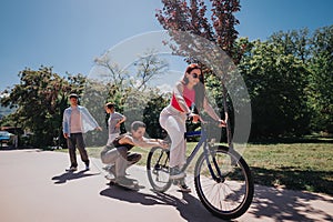 Group of friends enjoying a sunny day in the park, riding bikes and skateboards