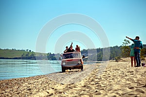 Group of friends go on the shore of Lake Baikal in a car.