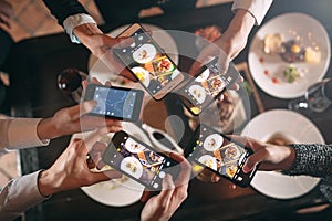 Group of friends going out and taking a photo of food together with mobile phone