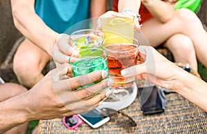 Group of friends hands drinking summer cocktails at beach bar