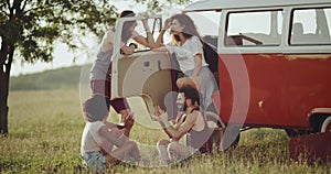 Group of friends have a good time together in the middle of nature playing with hands , standing up beside of a retro