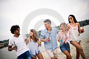 Group of friends having fun on the beach. Summer holidays, vacation and people concept.