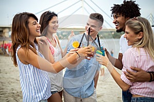 Group of friends having fun on the beach. Summer holidays, vacation and people concept.